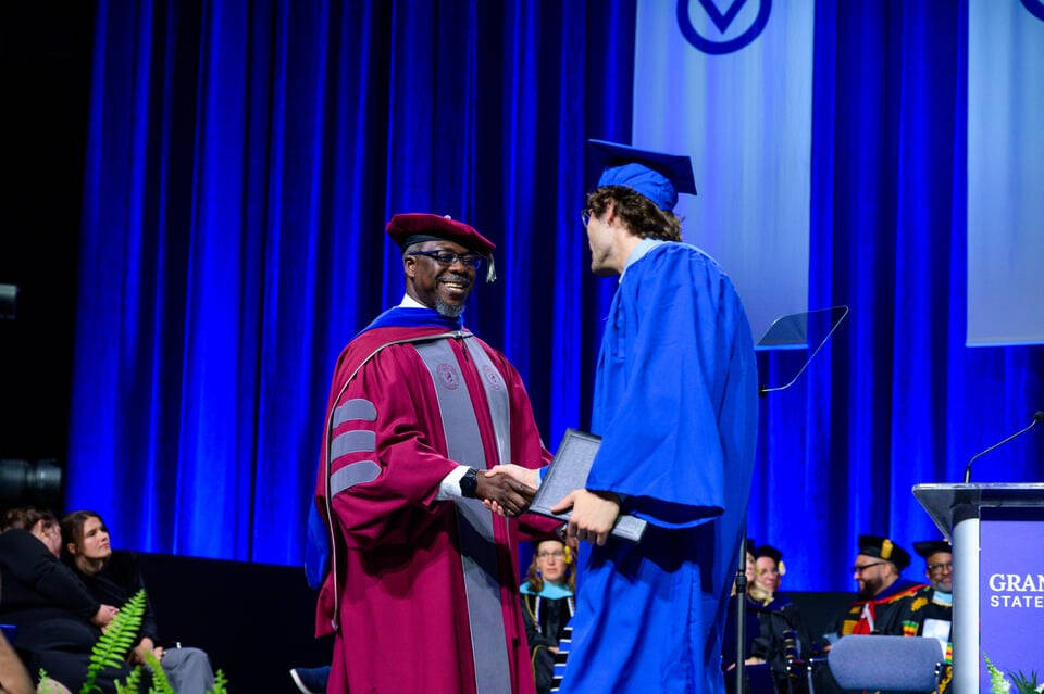 PCE Dean Bayo Ogundipe shakes hands with a graduating student at the May 1 commencement ceremony